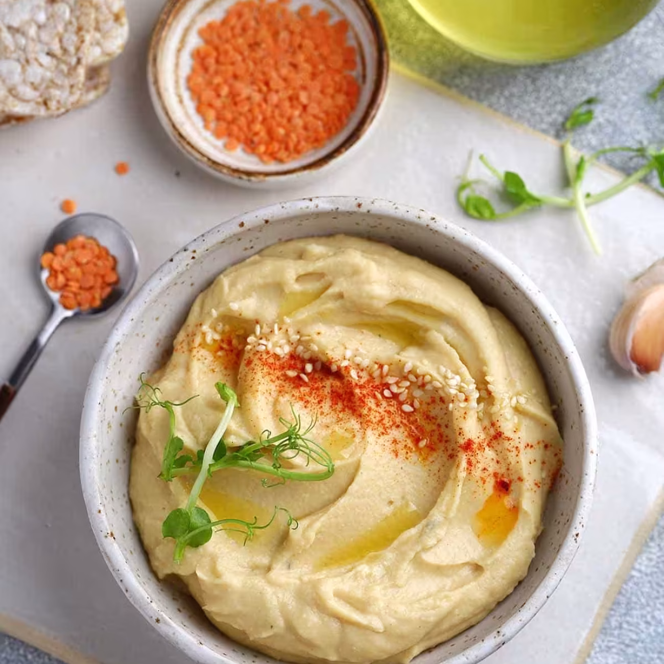 Hummus de lentejas rojas, curry y mango, servido con crudité de verduras y nachos (V,SG)